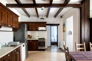 a kitchen with wooden cabinets and a table with a dining room at SáBa Vendégház in Tapolca +25 photos