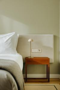 a bedroom with a bed and a table with a lamp at NINE DOTS Azorean Art Boutique Hotel in Ponta Delgada