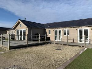 a house with a large deck in front of it at Seahorse Lodge at The Bay Filey, sleeps up to 6, and 2 dogs stay for free! in Filey