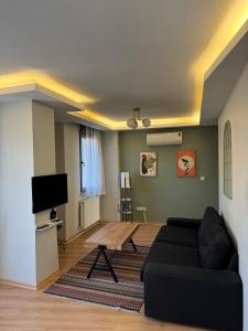 un soggiorno con divano nero e tavolo di İstanbul Relax Suite a Istanbul