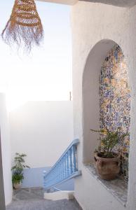 a stairway with a blue bench and a mosaic wall at Dar Yessine Boutique Hôtel in Sousse