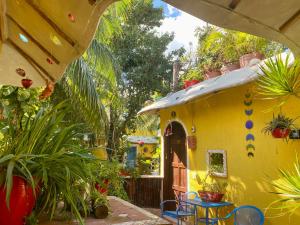 a yellow house with a yard with plants at Maison Tulum in Tulum