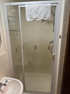 a shower with a glass door next to a sink at The George at Donyatt in Ilminster