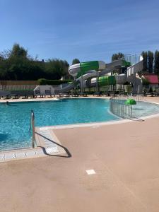 een groot zwembad met een glijbaan bij Mobil-home Ouistreham in Ouistreham