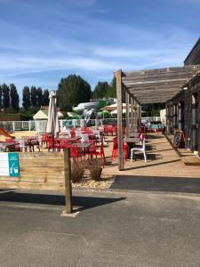 a deck with tables and chairs and a boat at Mobil-home Ouistreham in Ouistreham