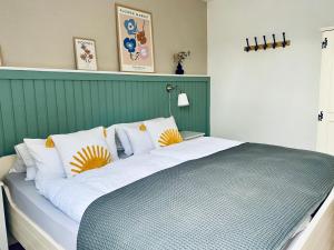 a large bed with white and yellow pillows on it at Kajüthus Apartment 1 in Fehmarn