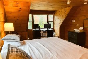 1 dormitorio con cama, escritorio y ventana en Peaceful Mountain Delight, en East Burke