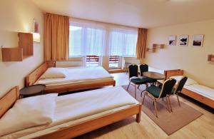 a room with two beds and a table and chairs at Pensjonat Markus in Przesieka