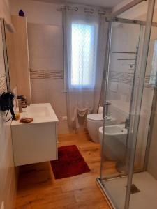 a bathroom with a shower and a sink and a toilet at New Bedrooms Mamma Gigetta in Noventa di Piave