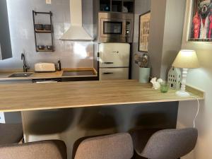 a kitchen with a wooden counter top and a refrigerator at Le Petit Palais in Escarrilla