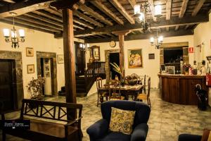 a living room with a table and a dining room at Hotel Rural Palacio de Galceran in Sotiello