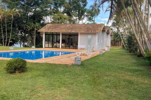 een huis met een zwembad in een tuin bij Sítio Dadedi in Ibiúna