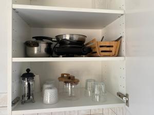 a cupboard filled with pots and pans and other kitchen items at Hübsches Cottage in ehemaliger Gärtnerei in Meerbusch
