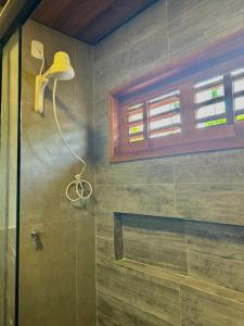uma casa de banho com um chuveiro e uma porta de vidro em Pousada Lá em Casa em Barra Grande