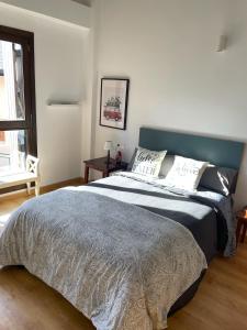 a bedroom with a large bed with a blue headboard at Le Petit Palais in Escarrilla