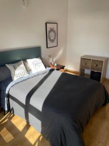 een slaapkamer met een bed met een zwart-witte deken bij Le Petit Palais in Escarrilla