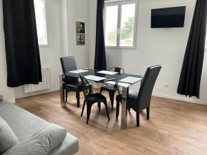 ein schwarzer Esstisch und Stühle in einem Wohnzimmer in der Unterkunft Résidence Le Gond in Le Gond