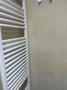 a bathroom with a shower with white tiles at Le Petit Palais in Escarrilla