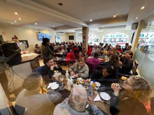 un grupo de personas sentadas en mesas en un restaurante en Hotel Astur en Salta