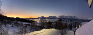 a view of a river with snow covered mountains at Panoramic Penthouse in Trondalen