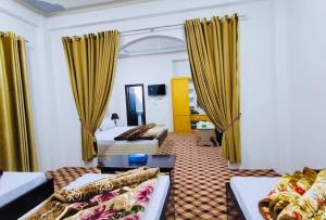 um quarto com duas camas e cortinas amarelas em Relax hotel em Kalām