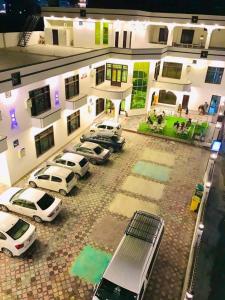 um grupo de carros estacionados em frente a um edifício em Relax hotel em Kalām