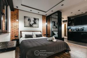 een slaapkamer met een bed en een bakstenen muur bij Happy Night - Happy Apartamenty Mielec in Mielec
