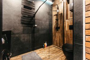 a bathroom with a toilet and a glass shower at Happy Night - Happy Apartamenty Mielec in Mielec