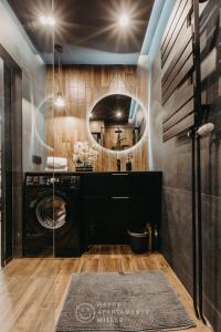 een badkamer met een wasmachine en een spiegel bij Happy Night - Happy Apartamenty Mielec in Mielec