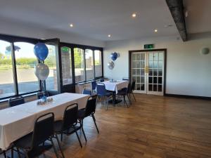 a banquet hall with two tables with balloons on them at The White Horse Lodge Hotel in Thirsk