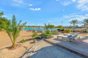a park with a bench and palm trees and water at El Gouna Rihana House sea view in Hurghada