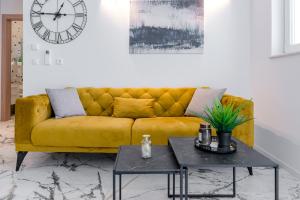 a yellow couch in a living room with a table at Sunset Premium Residence II & III in Dubrovnik +32 photos