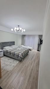 ein weißes Schlafzimmer mit einem Bett und Holzboden in der Unterkunft AIRPORT 24&24 CAR PARKING in Chişinău