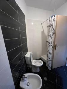 a small bathroom with a toilet and a sink at Asli's Comfy Studio APT in Tirana +5 photos