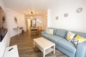 Una sala de estar con un sofá azul y una mesa. en Apartamentos El balcón de la Trinidad Córdoba - GREAT LOCATION, en Córdoba