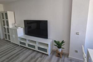 een woonkamer met een flatscreen-tv op een witte kast bij Coqueto Apartamento en la Playa in Daimús