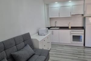 Il comprend un salon avec un canapé et une cuisine. dans l'établissement Coqueto Apartamento en la Playa, à Daimús