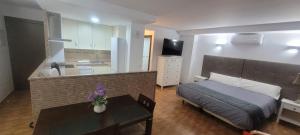 アルダレスにあるApartamentos lunaのベッドルーム1室(ベッド1台、テーブル付)、キッチン