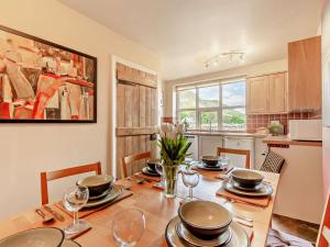 uma sala de jantar com uma mesa com pratos e copos de vinho em 3 Bed in Borrowdale SZ148 em Grange