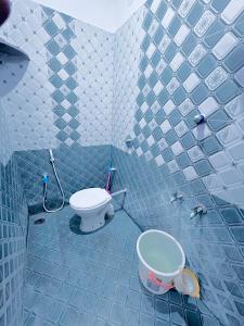 a blue tiled bathroom with a toilet and a sink at SS Home Stay Accomodation in Tiruvannāmalai