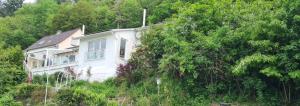 una casa sul fianco di una collina con alberi di Haus an der Weser Ferienwohnung a Brevörde