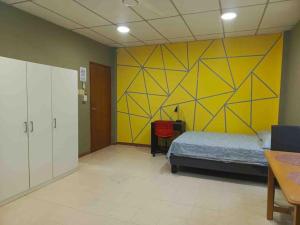 a bedroom with a bed and a yellow wall at Suite in Urdesa Central Guayaquil in Guayaquil