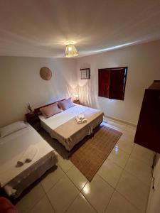a bedroom with two beds and a tv in it at La Bahianita in Itacaré