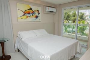 - une chambre avec un lit blanc et une fenêtre dans l'établissement Qavi - Flat Vista Mar em Resort Beira Mar Cotovelo #InMare230, à Parnamirim