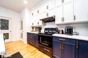 a kitchen with blue cabinets and a stove top oven at The Obsolete Suite - King Bed - Fireplace - Pet Friendly in Edmonton