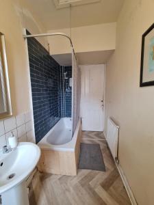 een badkamer met een bad en een wastafel bij Apex Haymarket Station Apartment in Edinburgh