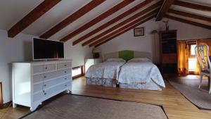 a bedroom with two beds and a flat screen tv at Casa la palmera in Gormazo