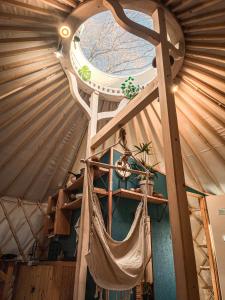 a room with a hammock in a yurt at Aloha Glamp - Domki z prywatnym jacuzzi & balia & sauna in Zagórnik