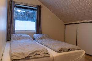 a bed in a room with a window at Panoramic Penthouse in Trondalen