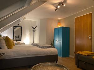 1 dormitorio con 1 cama y armario azul en Bed and breakfast Carma Arnhem, en Arnhem